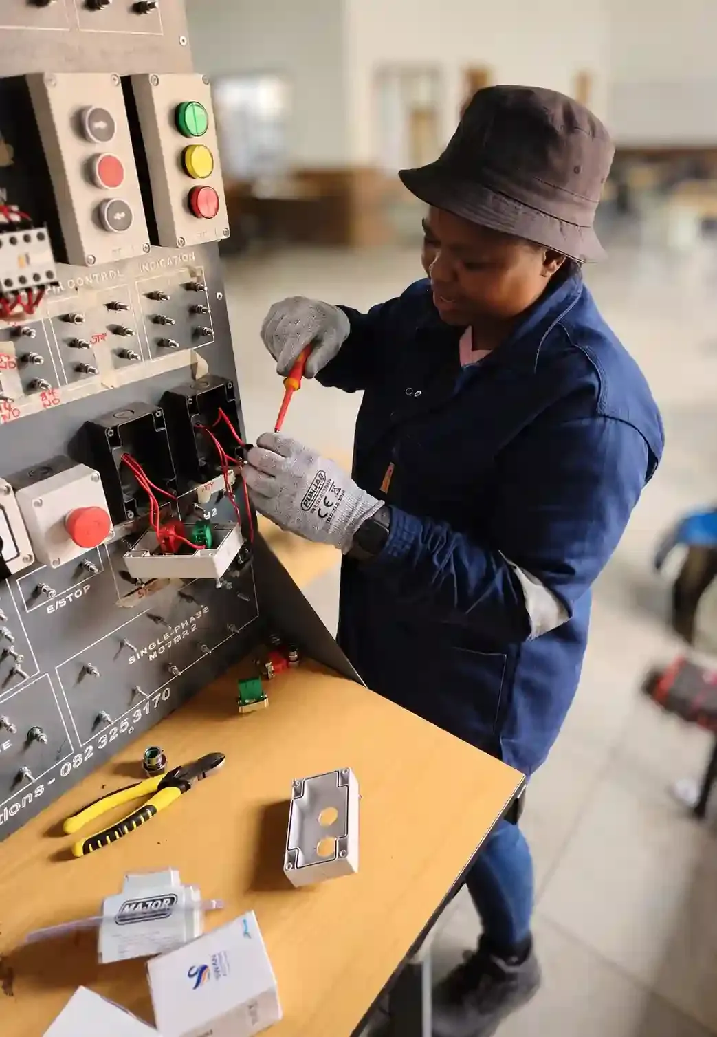 Woman technician completing electrical control panel work